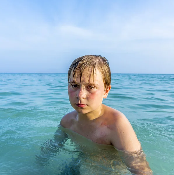 Menino zangado no belo oceano com queimadura solar — Fotografia de Stock