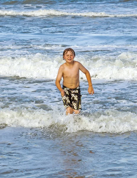 Heureux jeune garçon souriant jouit de l'océan — Photo