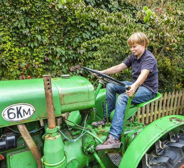 Pojke leker med en gammal traktor — Stockfoto