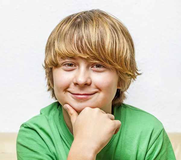 Lächelnder Junge sitzt auf einem Sofa — Stockfoto