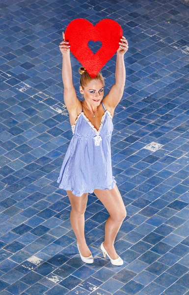 Beautiful woman with a red heart in her hand — Stock Photo, Image