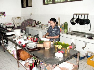 woman prepares in the kitchen a duck balinese style clipart