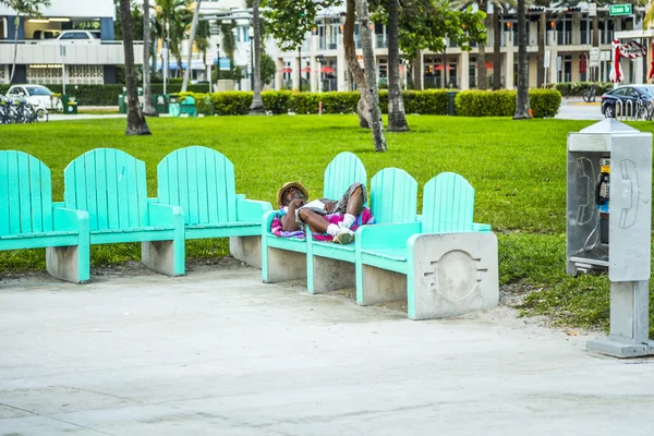 Dakloze mensen slapen op een bankje in South Beach — Stockfoto