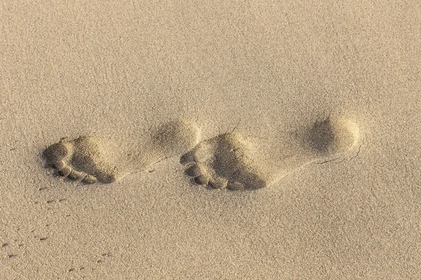 Voetafdrukken op geel zand — Stockfoto