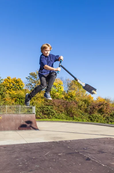 Kind gaan airborne met scooter — Stockfoto