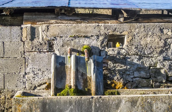 Alter wasserbrunnen auf einem bauernhof an der seigne des alps — Stockfoto