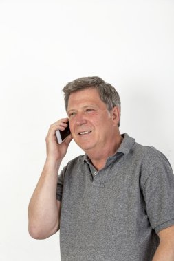 Olgun adam gri polo gömlek Mobile ile gülümseyen