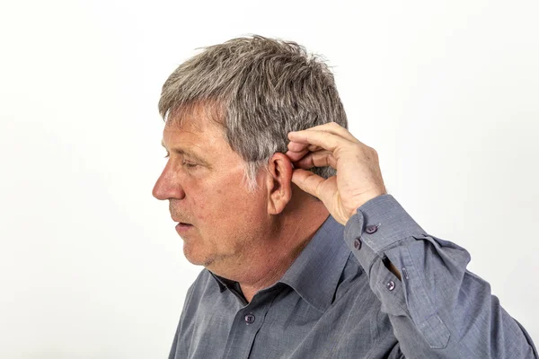 Człowiek stawia aparat słuchowy w uchu — Zdjęcie stockowe