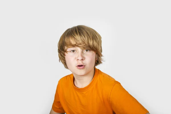 Zaskoczony chłopak w shirt pomarańczowy — Zdjęcie stockowe