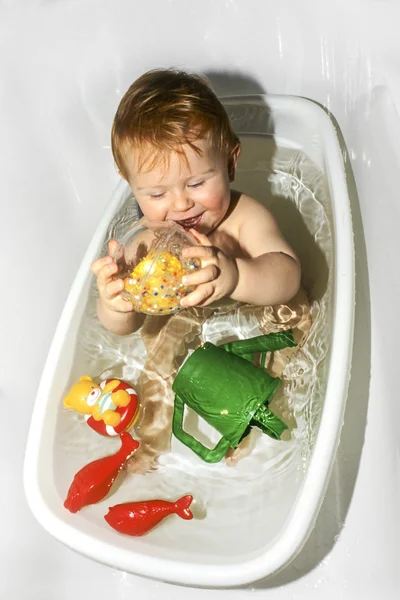 Pojke tycker om att spela med plastleksaker — Stockfoto