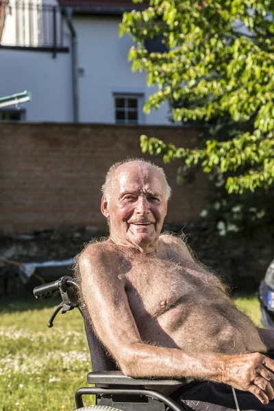 Senior sits in the chair in the garden — Stock Photo, Image