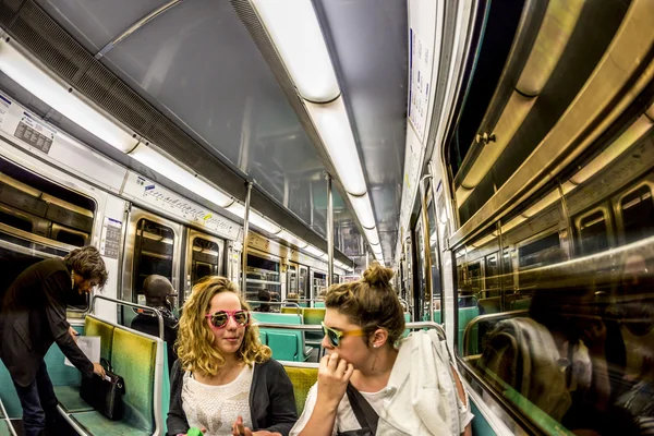 Turistas y lugareños en un tren subterráneo en París — Foto de Stock