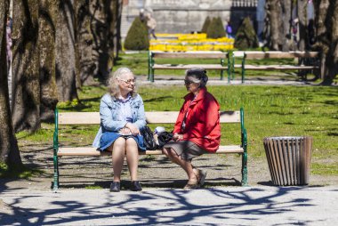 insanlar bir bankta mirabell bahçesinde rahatlayın 