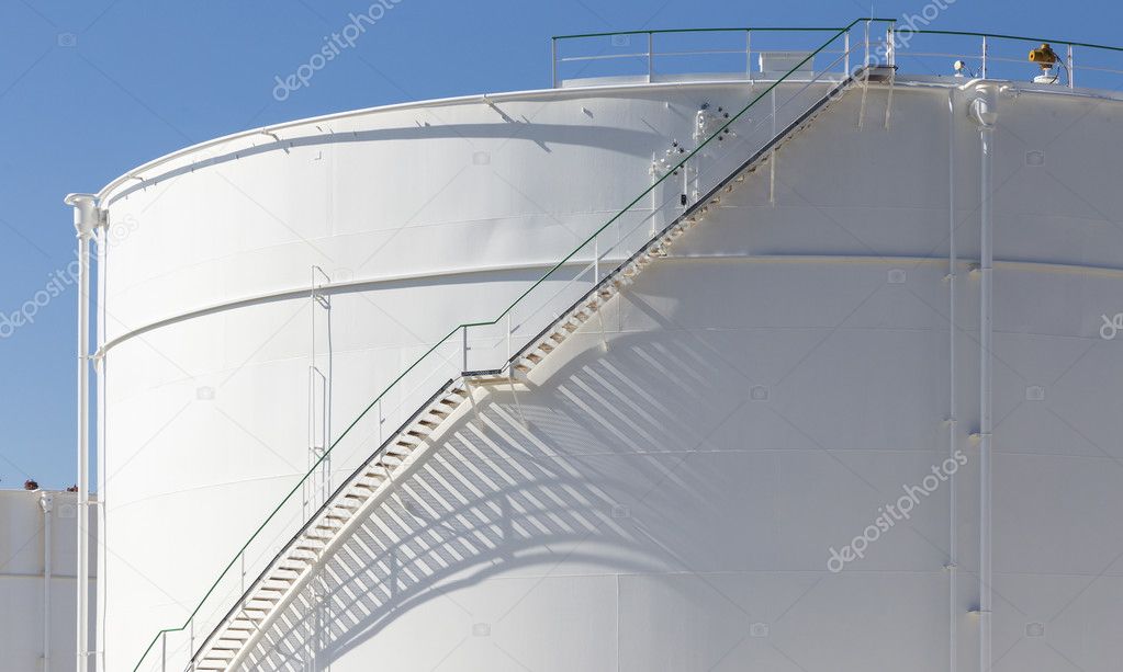 white tanks in tank farm with iron staircase  