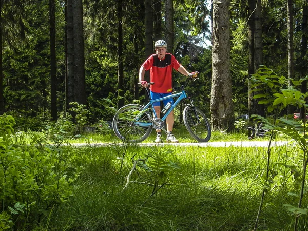 Man enjoys ridimg mountain bike in the forest — 图库照片