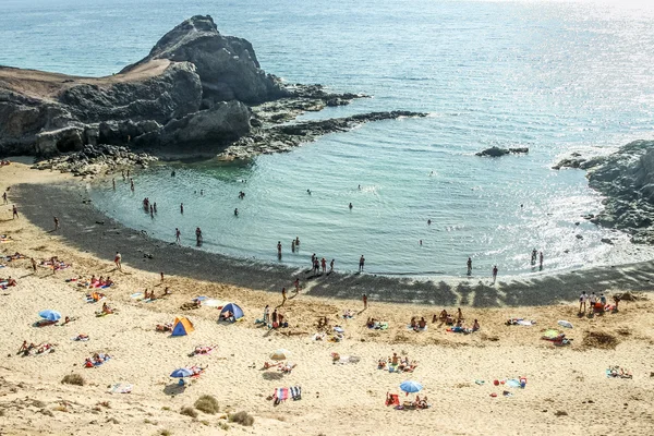 Turistler bir güneşli bahar gününde Papagayo kumsalın tadını çıkar — Stok fotoğraf