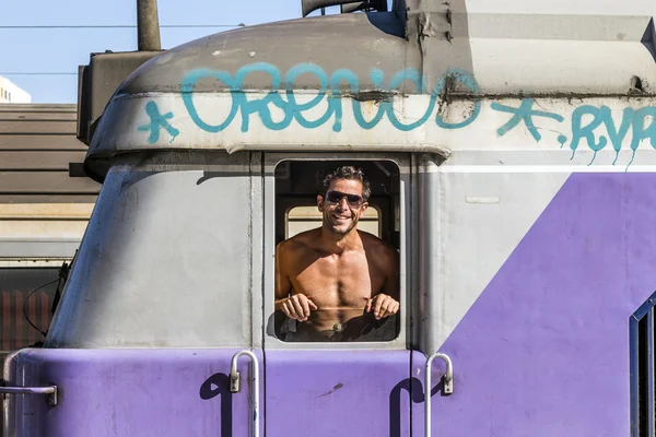 Attractive train conductor in his train is proud to show his mu — Stock Photo, Image