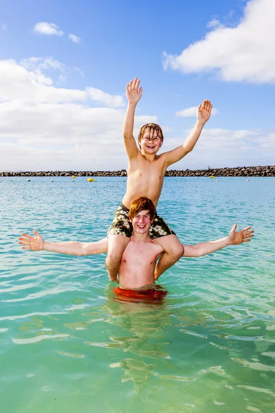 Boys having fun in the clear sea — Stock Photo, Image