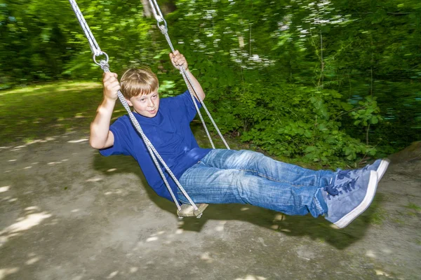 Boy has fun going on the swings — Stock Photo, Image