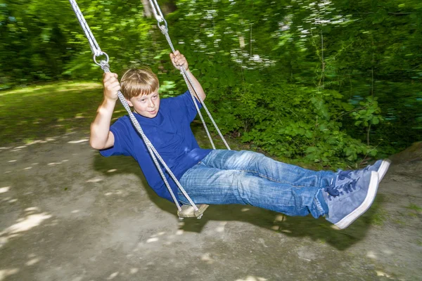 Pojken har kul går på gungorna — Stockfoto