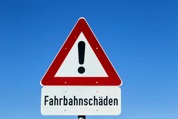 Straßenschild - Straßenschäden - mit Warnsymbol — Stockfoto