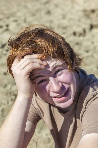 Tonårspojke med rött hår på stranden — Stockfoto