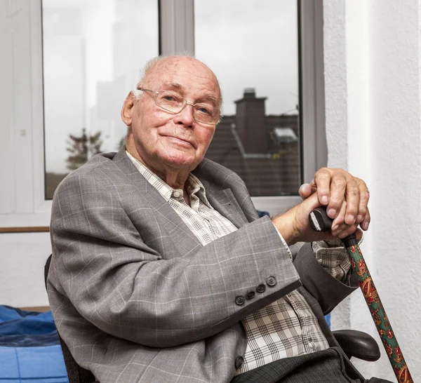Sonriente hombre mayor se sienta en la silla —  Fotos de Stock