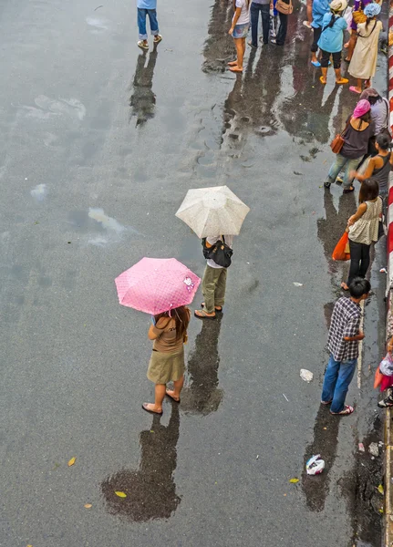 As pessoas esperam o ônibus no mercado de fim de semana Chatuchak na chuva — Fotografia de Stock