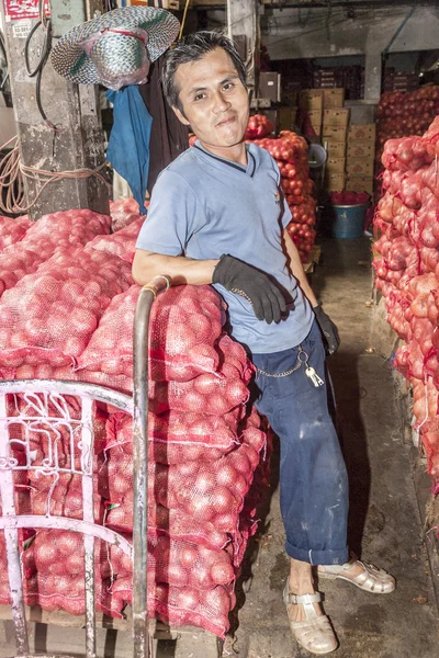 Unidentified  man transports sacks of onions i — Stock Photo, Image