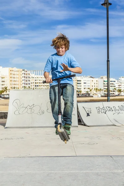 Boy with scooter is going airborne — Zdjęcie stockowe