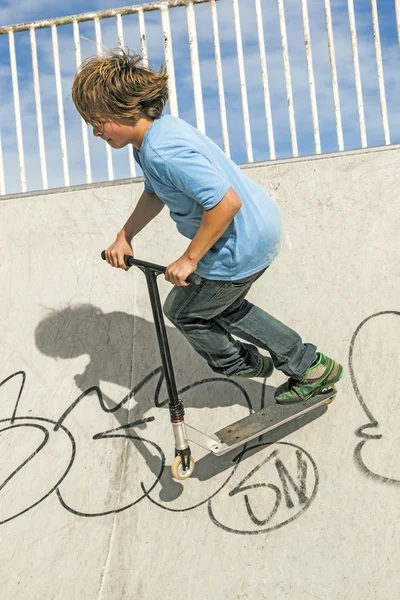 Boy with scooter is going airborne — Zdjęcie stockowe