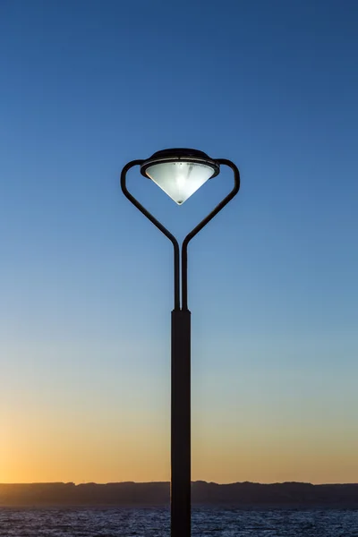Lanterna con luce ardente al tramonto alla Corniche — Foto Stock