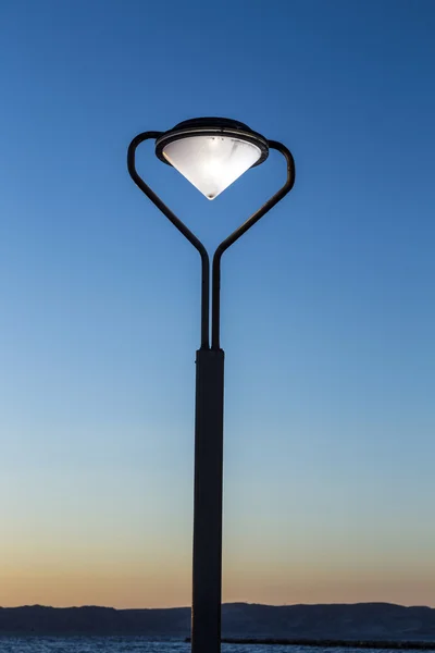 Lanterna con luce ardente al tramonto alla Corniche — Foto Stock