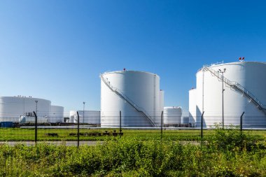 Enerji sembolü olarak gün ışığında beyaz benzin siloları