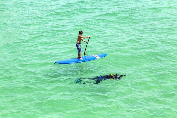 People  enjoy Stand Up Paddle Surfing and diving in the ocean — Stock Photo, Image