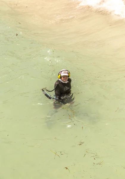 Homem procura com detector de metais para tesouros no oceano — Fotografia de Stock