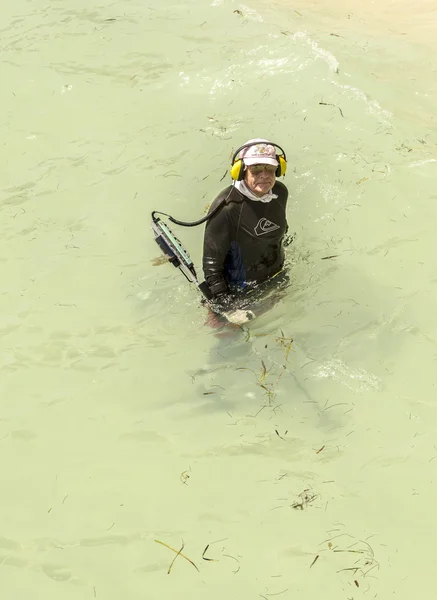 Uomo cerca tesorerie nell'oceano con metal detector — Foto Stock
