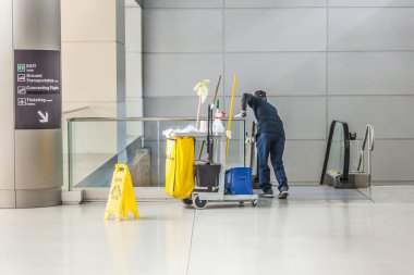 Temizlikçi kadın temizlik onun arabası ile bir st bardak temizler