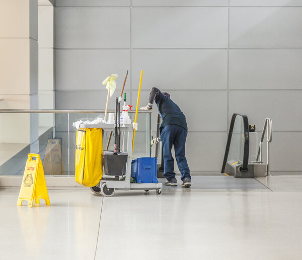 уборщица с тележкой для уборки чистит стакан
