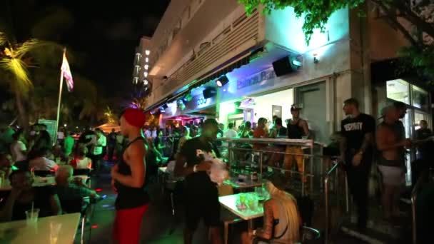 La gente disfruta de la noche en el paseo marítimo en Miami Beach — Vídeo de stock