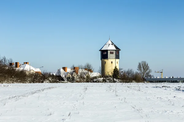 Snow covered houses and old water tower in snow — Stock Fotó