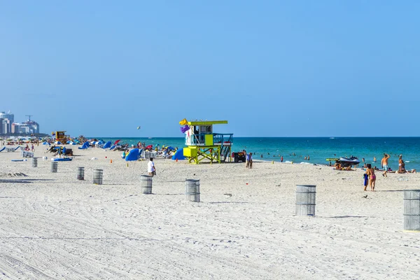 Les gens apprécient la plage à côté d'une tour de sauveteur — Photo