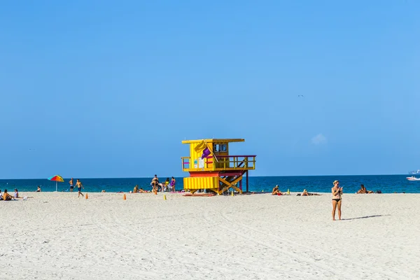 Les gens apprécient la plage à côté d'une tour de sauveteur — Photo