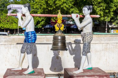 Bir çan tutan iki adam heykeli
