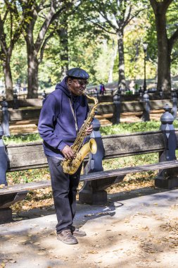 Adam New York 'taki Central Park' ta saksafon çalıyor.