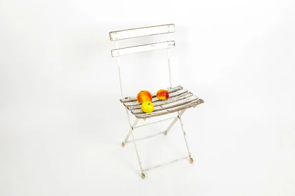 Maçãs na cadeira em estúdio sobre fundo branco isolado — Fotografia de Stock