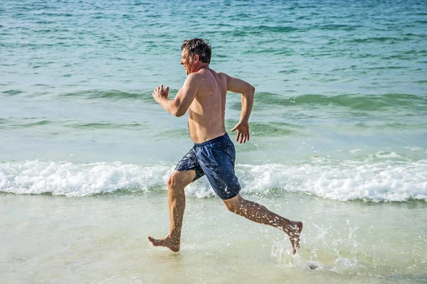 Homem corre ao longo da bela praia , — Fotografia de Stock