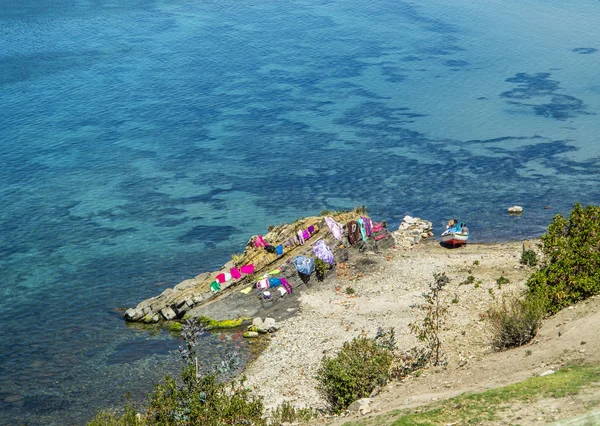 Clothes from local people keep drying at a rock — Stock Photo, Image