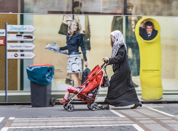 Islamiska kvinna med hennes barn i en barnvagn — Stockfoto