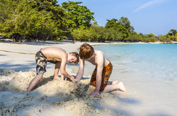 Boys are playing at the  tropical beach with sand — Zdjęcie stockowe